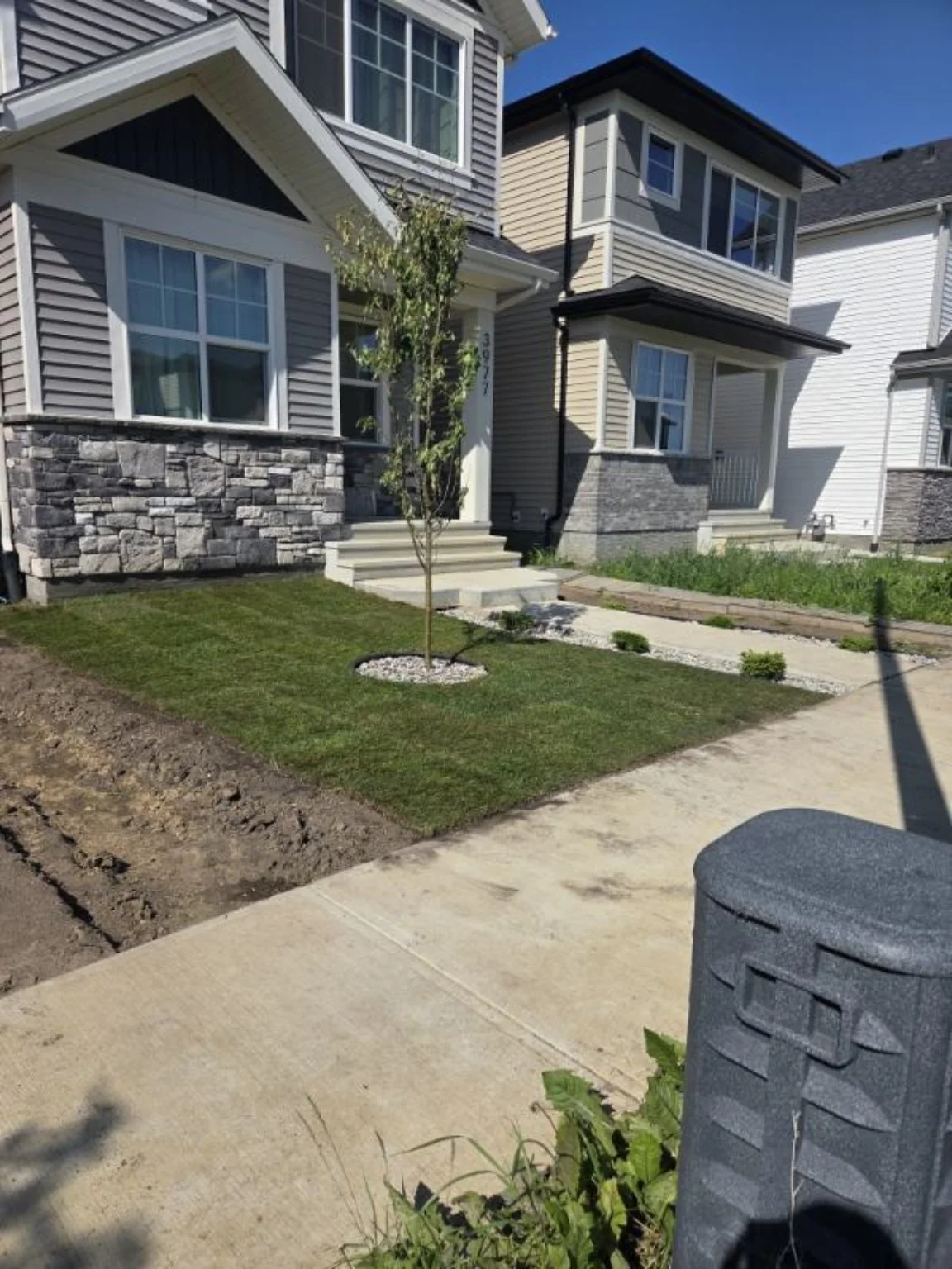 Finished front yard with sod, tree and rock beds